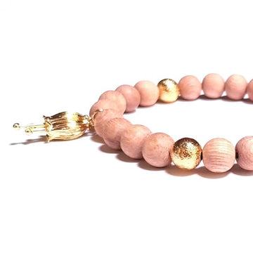 Close up of Handmade Golden Flower Bracelet – Rosewood & Gold for Balance & Prosperity on white table with Gold Flower Charm
